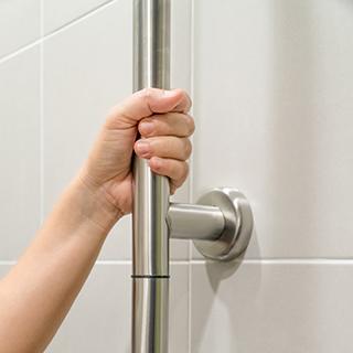 Woman holding on handrail in toilet